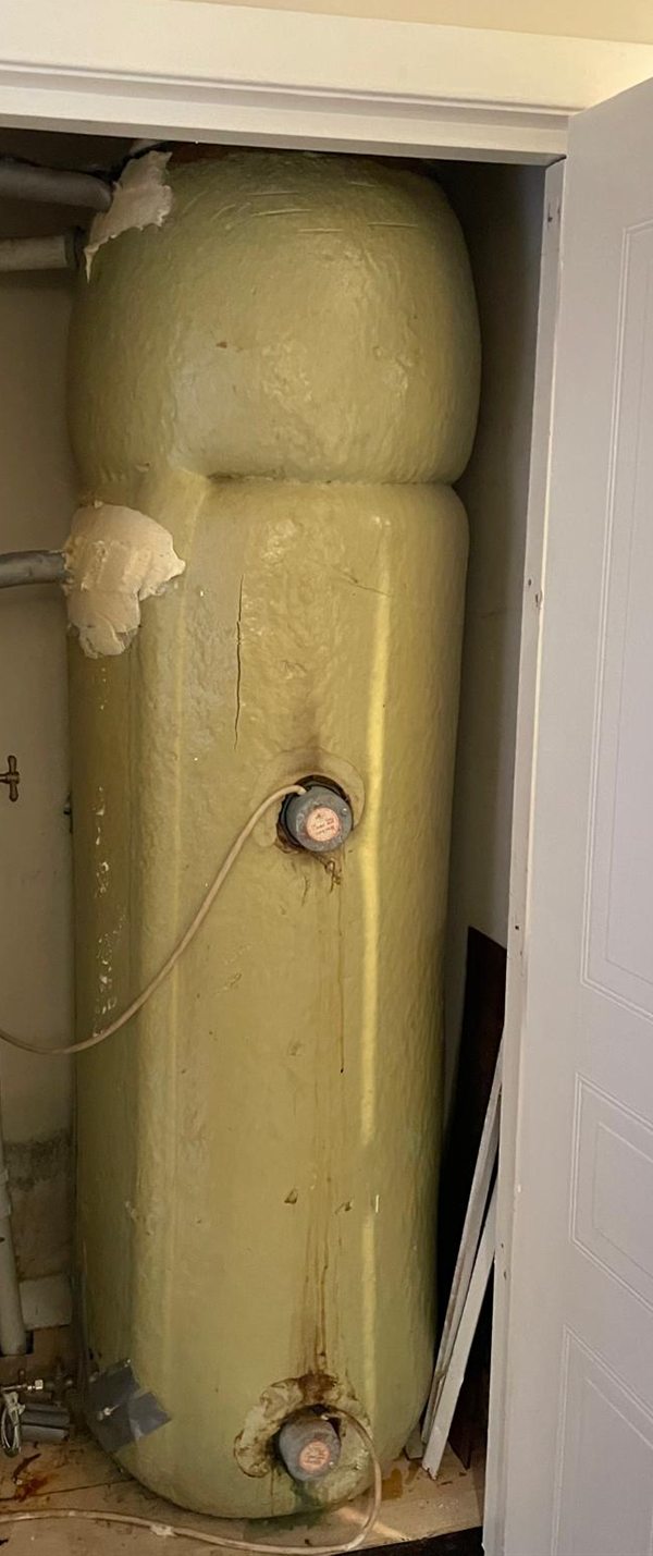 Before: old foam-lagged hot water cylinder with rust streaks